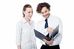 Businessman And Woman Looking At Folder Stock Photo