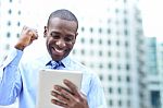 Businessman Celebrates His Success With Tablet Stock Photo