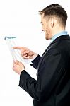 Businessman Cross-checking Annual Reports Stock Photo