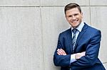 Businessman Leaning Against A Concrete Wall Stock Photo