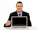 Businessman Pointing At Blank Laptop Screen Stock Photo