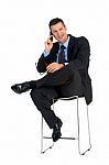 Businessman Sat Talking On Mobile Phone Stock Photo