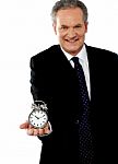 Businessman Showing Alarm Clock Stock Photo