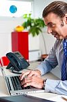 Businessman Typing Report On A Laptop Stock Photo