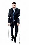 Businessman Walking With Crutches Stock Photo