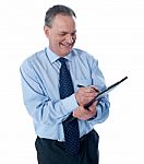 Businessman Writing On Clipboard Stock Photo