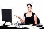 Businesswoman Holding Pen And Pointing Monitor Stock Photo