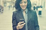 Businesswoman With Smartphone Walking On Street. Phone In Focus Stock Photo