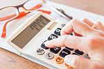 Businesswoman Working In Coffee Shop With Calculator Stock Photo