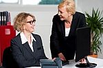 Businesswomen Enjoying At Work Desk Stock Photo