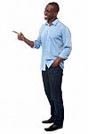 Casual African Man Pointing Away Stock Photo