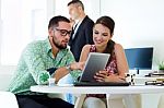 Casual Executives Working Together At A Meeting With Digital Tab Stock Photo