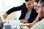 Casual Executives Working Together At A Meeting With Laptop Stock Photo