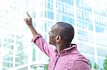 Casual Man Pointing With His Finger To The Building Stock Photo