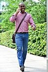 Casual Man Talking On The Phone While Walking Stock Photo