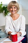 Casual Woman In Office Enjoying Her Coffee Break Stock Photo