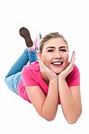 Casual Young Caucasian Girl Lying On Studio Floor Stock Photo