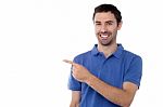 Casual Young Man Pointing Away Stock Photo