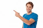 Casual Young Man Pointing Away Stock Photo