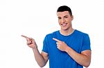 Casual Young Man Pointing Away Stock Photo