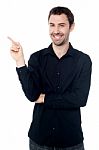 Casual Young Man Pointing Away Stock Photo