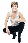 Charming Woman In Squatting Posture Stock Photo