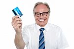 Cheerful Aged Employer Holding Up A Cash Card Stock Photo