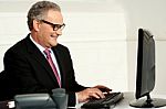 Cheerful Aged Man Working On Computer Stock Photo