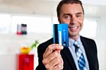 Cheerful Businessman Holding Up His Credit Card Stock Photo