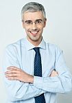 Cheerful Corporate Man With Arms Folded Stock Photo