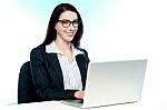 Cheerful Corporate Woman Using Laptop Stock Photo