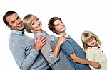 Cheerful Family Of Four Leaning Backwards Stock Photo