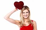 Cheerful Girl Holding Heart Shaped Gift Stock Photo