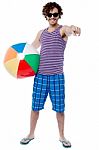 Cheerful Guy With Beach Ball Pointing At You Stock Photo