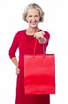 Cheerful Old Woman Holding Shopping Bag Stock Photo