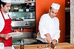 Chef Cutting Pizza Into Pieces Stock Photo