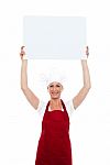 Chef Holding Board Over Her Head Stock Photo