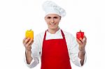 Chef In Uniform Showing Capsicums Stock Photo