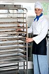 Chef Moving Tray Rack Towards Corner Stock Photo