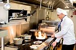 Chef Preparing  Cuisine In Hotel Kitchen Stock Photo