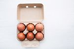 Chicken Eggs In Egg Box On White Wooden Background Stock Photo