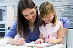 Child Drawing With Crayons With Her Mom At Home Stock Photo