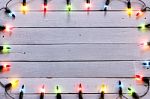 Christmas Light Decorations On Wood Texture Stock Photo