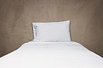 Close Up White Bedding And Pillow On Gray Concrete Background Stock Photo