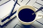 Coffee And Notebook On Wooden Table Stock Photo