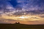 Colourful Cloudy Sky Sunset Behind A Small Hill Stock Photo