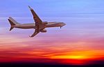 Commercial Airplane Flying At Sunset Stock Photo