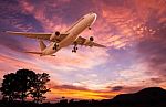 Commercial Airplane Flying At Sunset Stock Photo