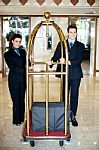 Concierge Team Holding Baggage Cart Stock Photo