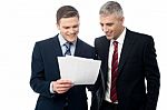 Confident Businessmen Reviewing Records Stock Photo